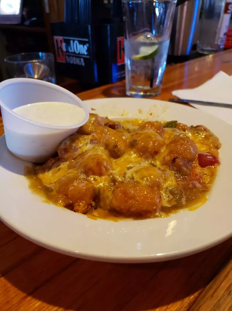 Image: Alibi's Bar and Grill is still serving up tots smothered in housemade green chile and cheese to go.