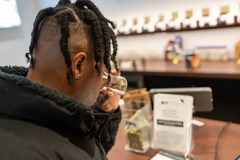 Image: Man smells marijuana inside of dispensary