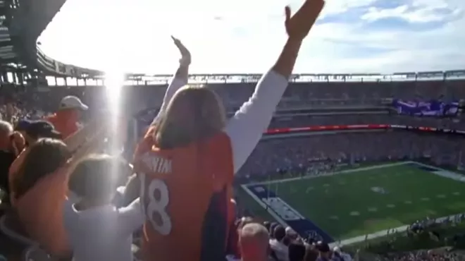 football fans with arms outstretche