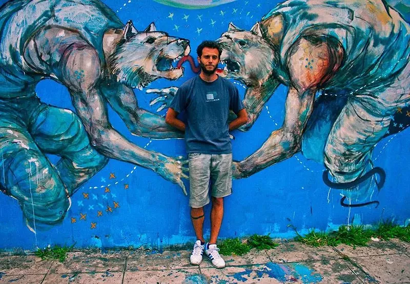Image: Argentinian artist Franco Fasoli (JAZ) poses with his mural. See his work at Mirus Gallery.