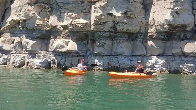 People kayak in a lake with mountains