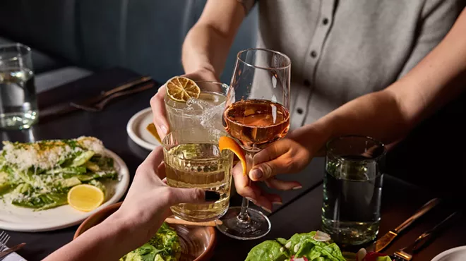 hands holding wine and cocktails