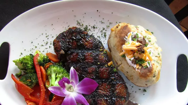 a steak on a plate with a baked potato