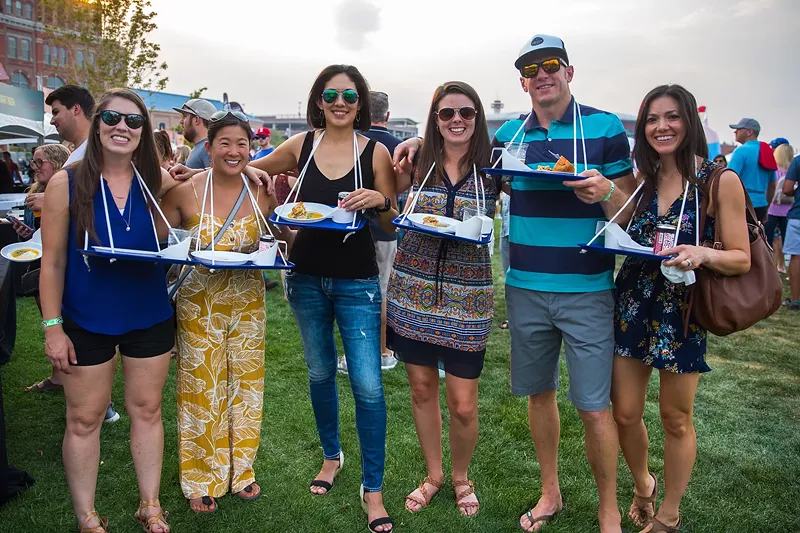 Image: people posing with trays of food
