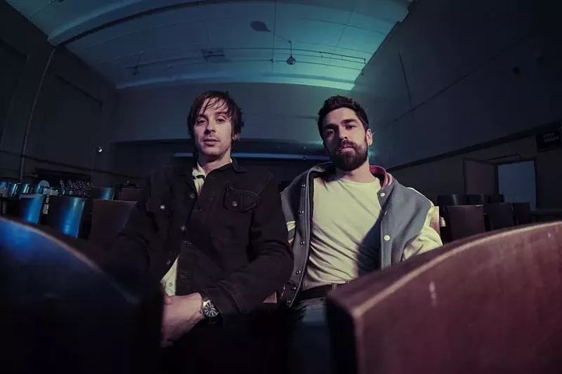 Image: two men in a dark room