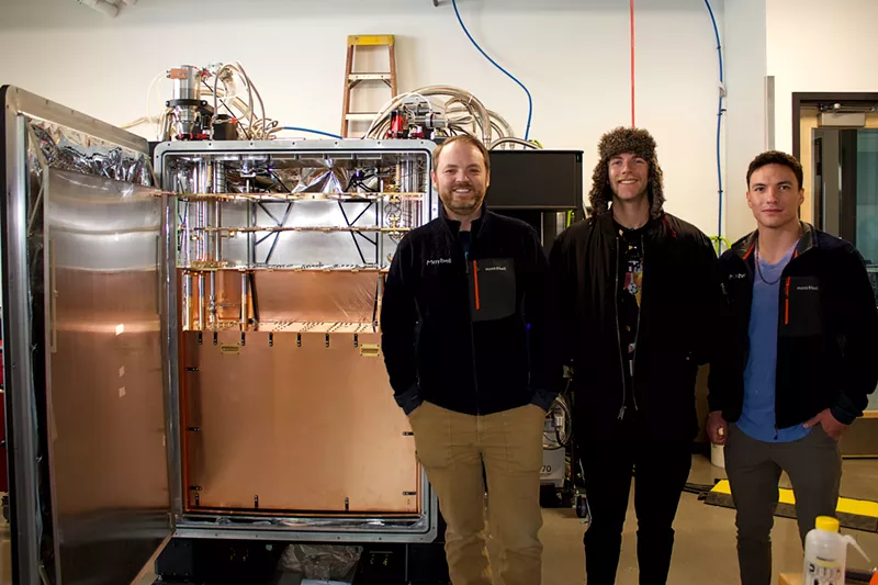 Image: Men stand in front of quantum fridge