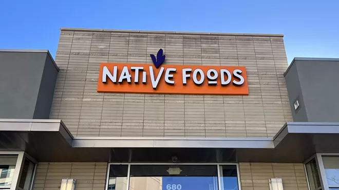 A tan brick building with orange signage reading "Native Foods"