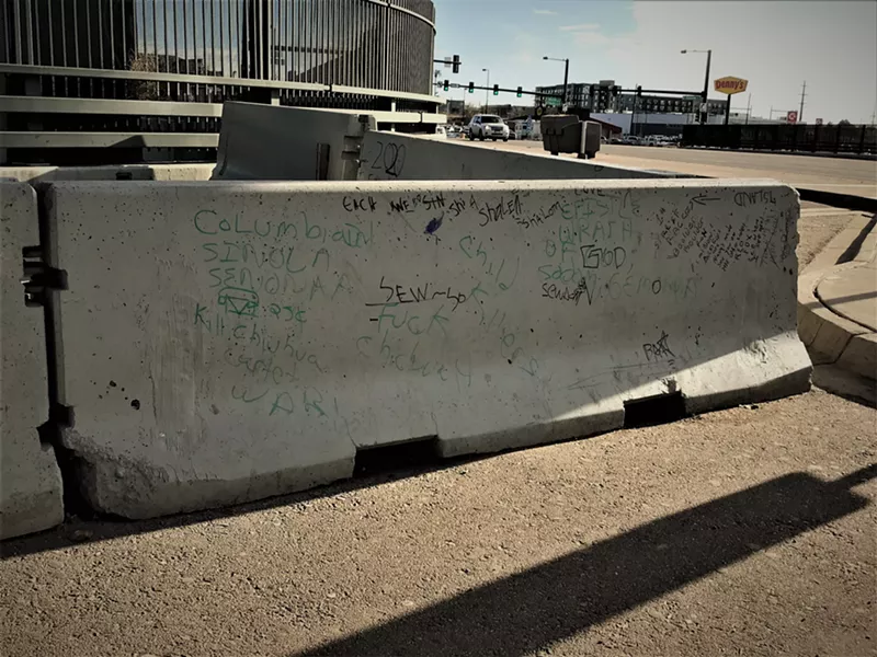 Image: A concrete barrier turned into a scratch pad on an off-ramp at the intersection of I-25 and Alameda.