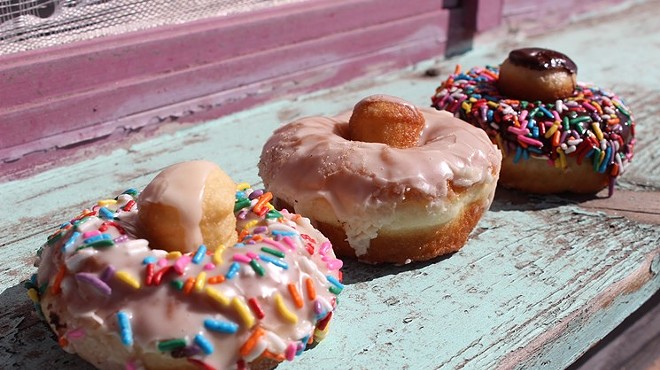 three doughnuts on a pastel table
