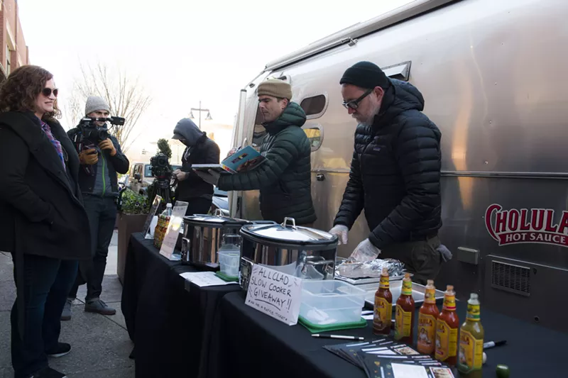 Image: Hugh Acheson (holding book) is touring to support his new slow-cooker cookbook.