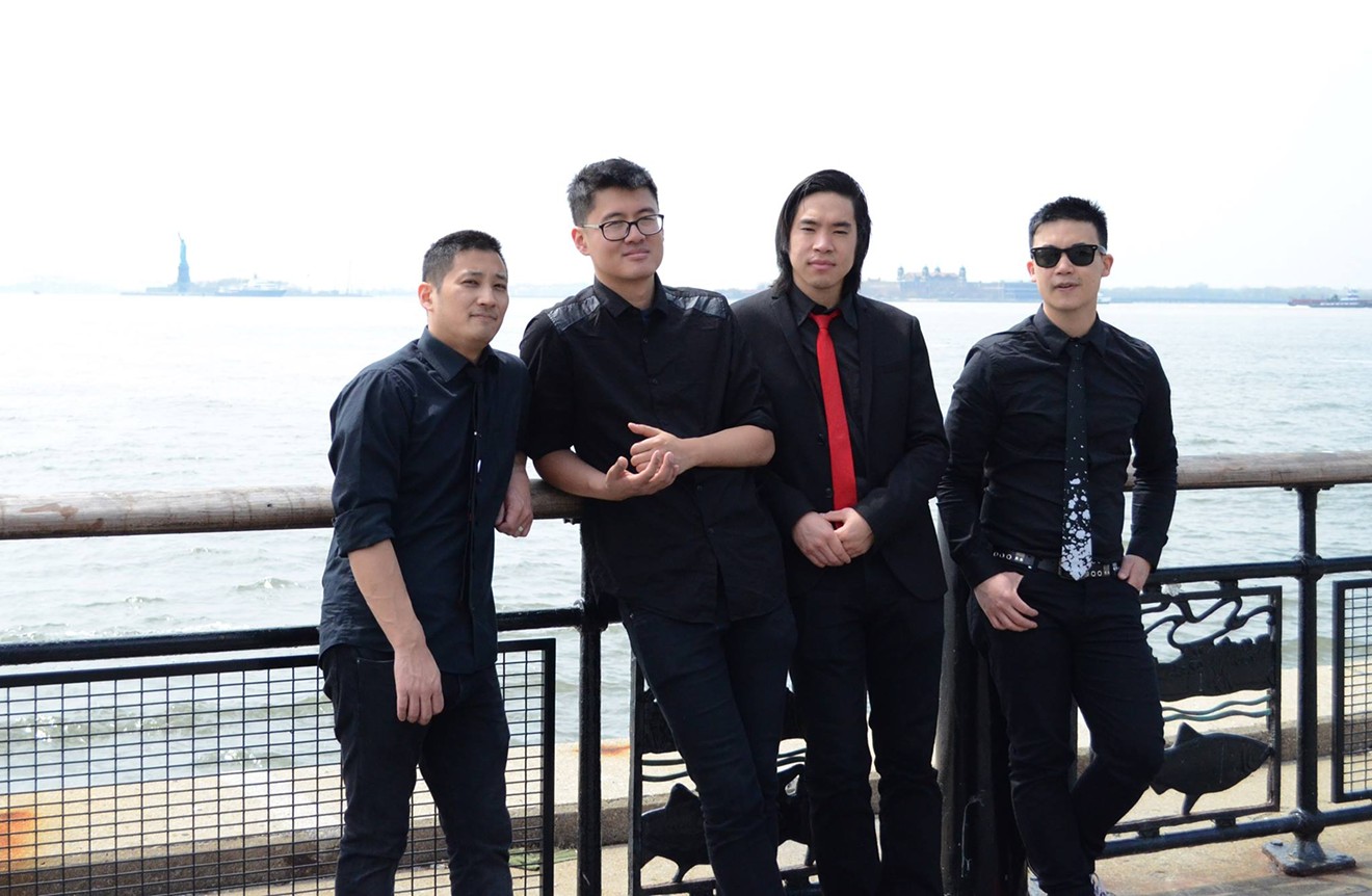 The Slants, an all-Asian American band of musicians fighting in court to trademark their group's name, stand in front of the Statue of Liberty.