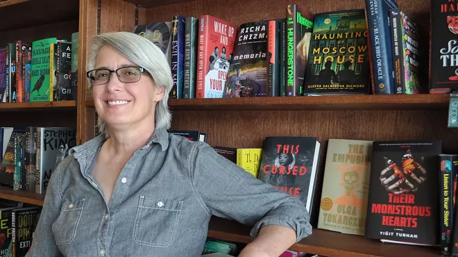 A woman next to bookshelves