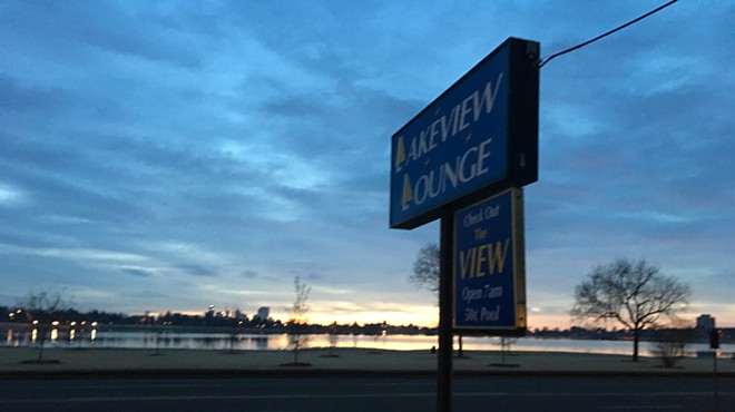 view of sunrise over lake from bar, with sign.