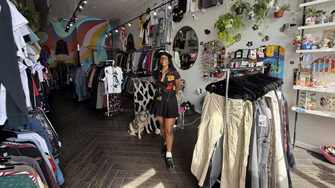 A woman and a dog stand in a vintage shop