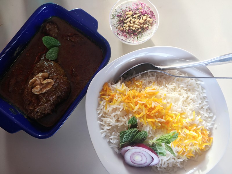 Fesenjan, a walnut-pomegranate stew with braised chicken, is served with fragrant rice and seasoned yogurt at Ladan's.