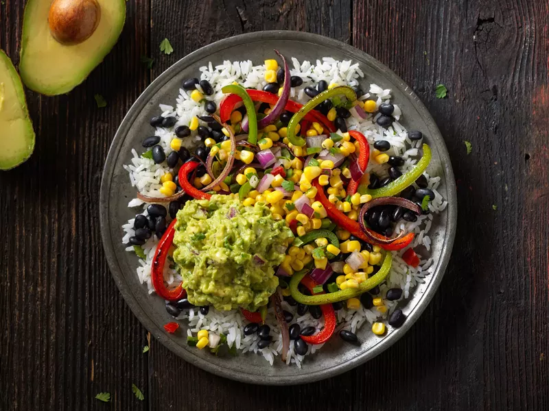 Image: Fajita veggies, salsas and guacamole are piled high in bowls, tacos, and burritos at Qdoba.
