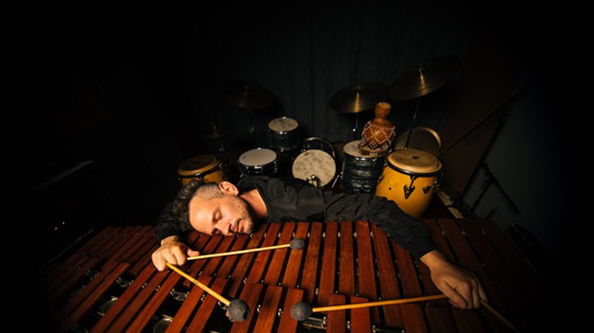 a man lies down with drum sticks