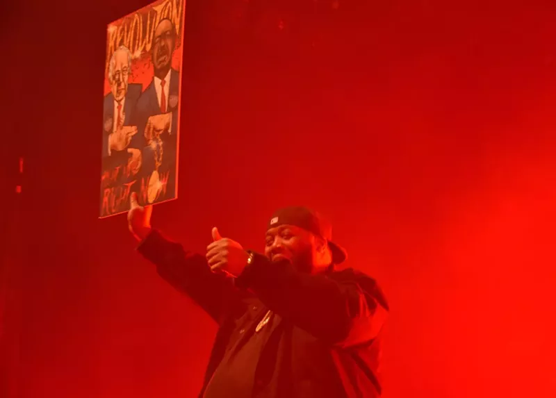 Image: Killer Mike shows off a poster, by Danny Argote, of Bernie Sanders and Martin Luther King Jr. flashing Run the Jewels signs.