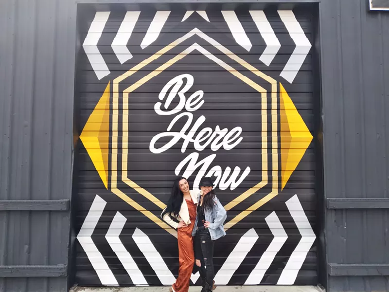 Image: Jasmine and Katrina Lairsmith in front of Pat Milbery's newest mural for their studio.