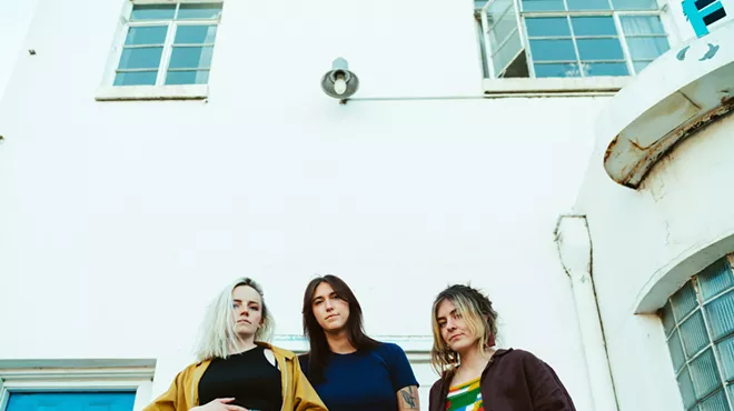 three women in front of a white building