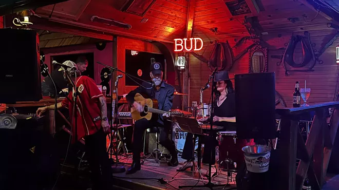 band performing on stage with red and purple lighting