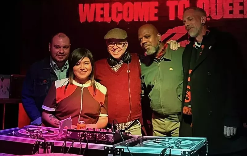 Image: The five DJs of Denver Vintage Reggae Society standing behind turntables