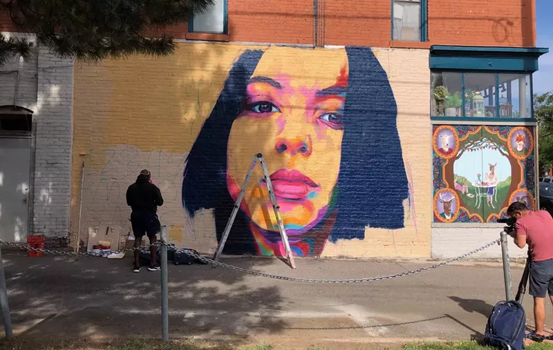 Image: Thomas "Detour" Evans at work on a mural of Isabella Thallas, who was murdered last week.