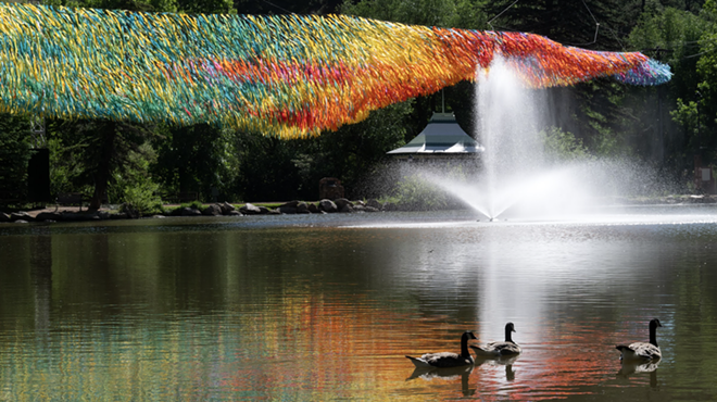 Colorful streamers hang over a body of water with ducks swimming