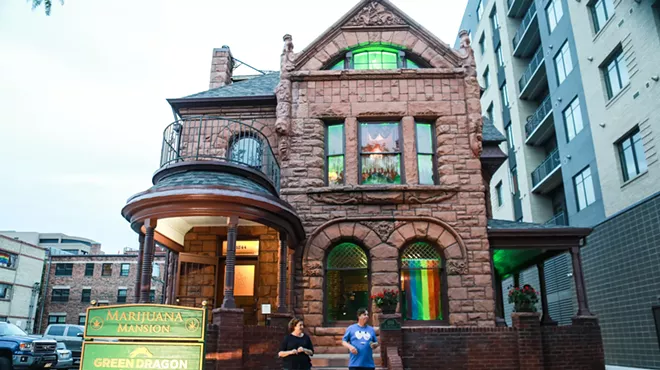 People stand outside of Denver's Marijuana Mansion in Capitol Hill