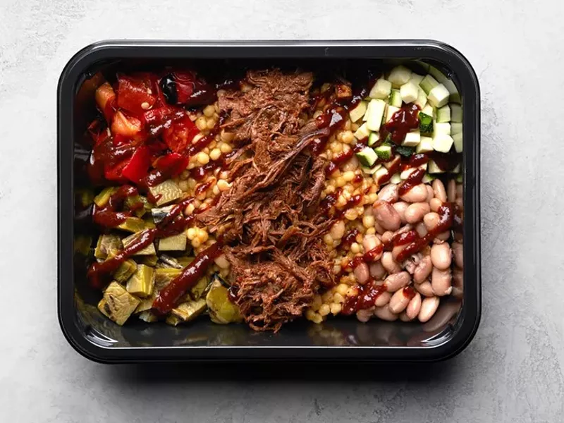 Image: black container with beans and food and bison on white table