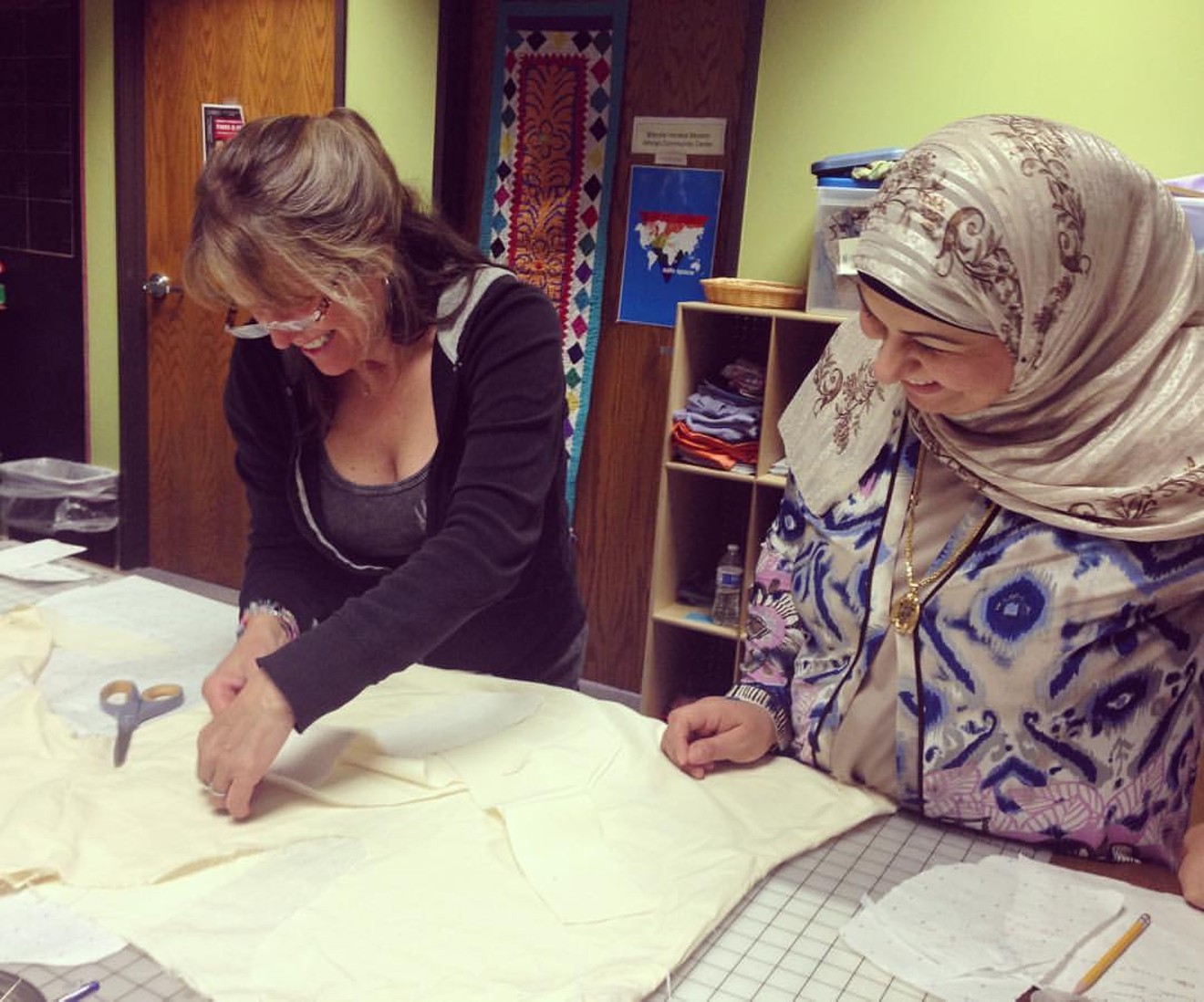 A local designer and a refugee woman work on a muslin prototype for their Designing Women collaboration.