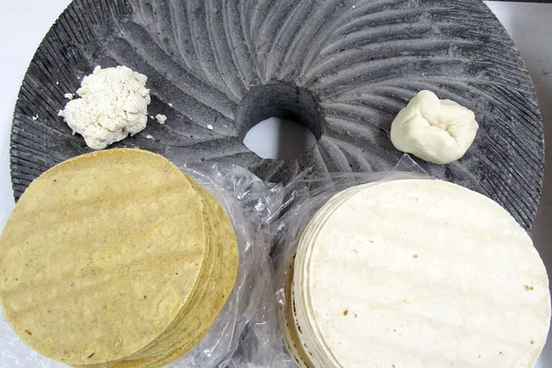 Image: Nixtamal (left) and Maseca (right) masa and tortillas on a stone wheel from the corn grinder at Raquelitas.