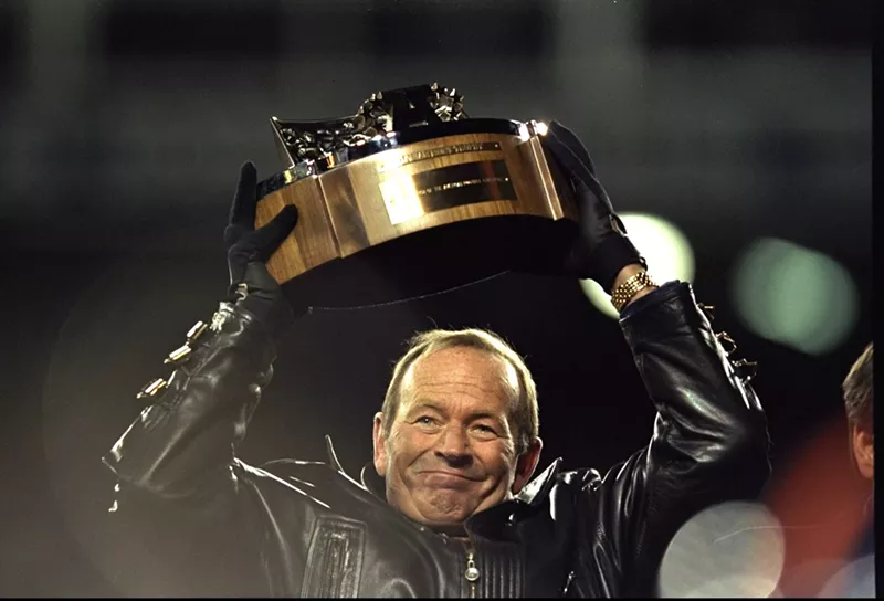 Image: Pat Bowlen holds up the trophy after the Denver Broncos won the AFC Championship Game at Mile High Stadium in 1999.