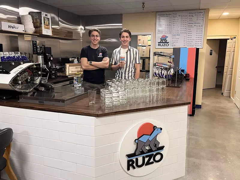Image: Two men standing behind a coffee shop counter