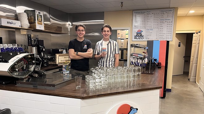 Two men standing behind a coffee shop counter