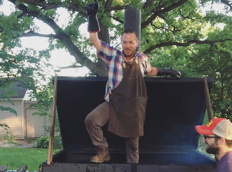 Jared Leonard on top of a smoker in Chicago. - STONE SOUP COLLECTIVE