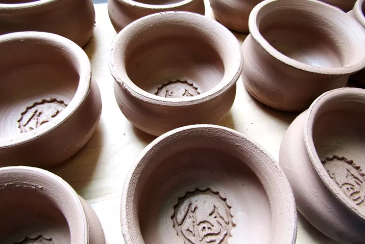 Ceramics artist Nathan Mencini carved the Cochino Taco logo in wood to use as a clay stamp. - MARK ANTONATION