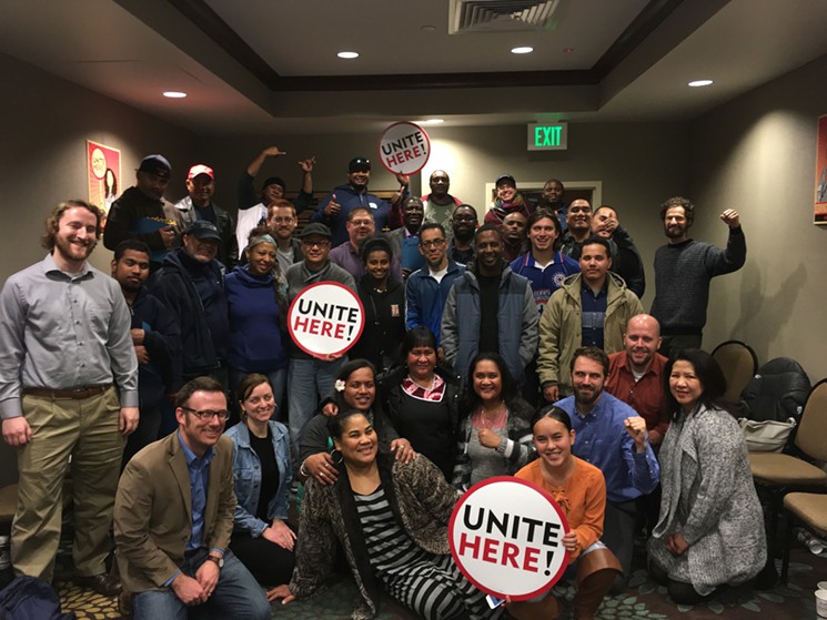 United catering workers displaying pro-union swag. - COURTESY OF UNITE HERE