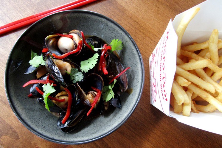 Mussels in black bean sauce with a takeout container of fries. - MARK ANTONATION