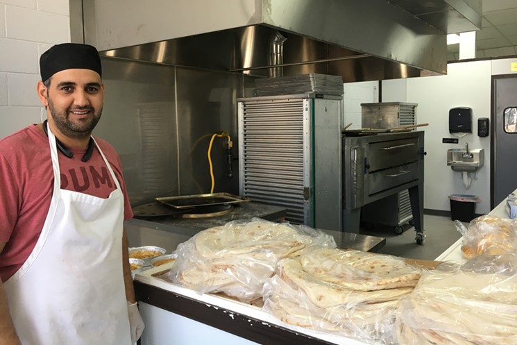 Shahrazad owner/baker Bassam Salih with a fresh batch of flatbread. - MARK ANTONATION