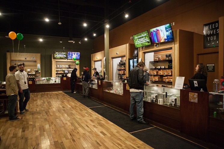 Customers shop inside of a retail marijuana dispensary.