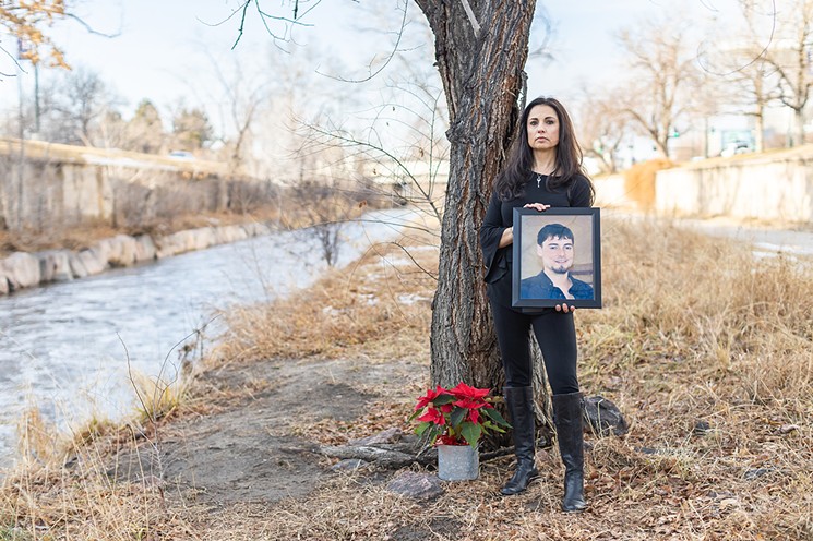 Joelle Fairchild with a portrait of her son Tony next to the tree where he passed away. - JAKE HOLSCHUH