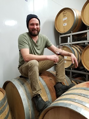Carboy winemaker Tyzok Wharton samples some of his product in the barrel room. - KRISTA KAFER