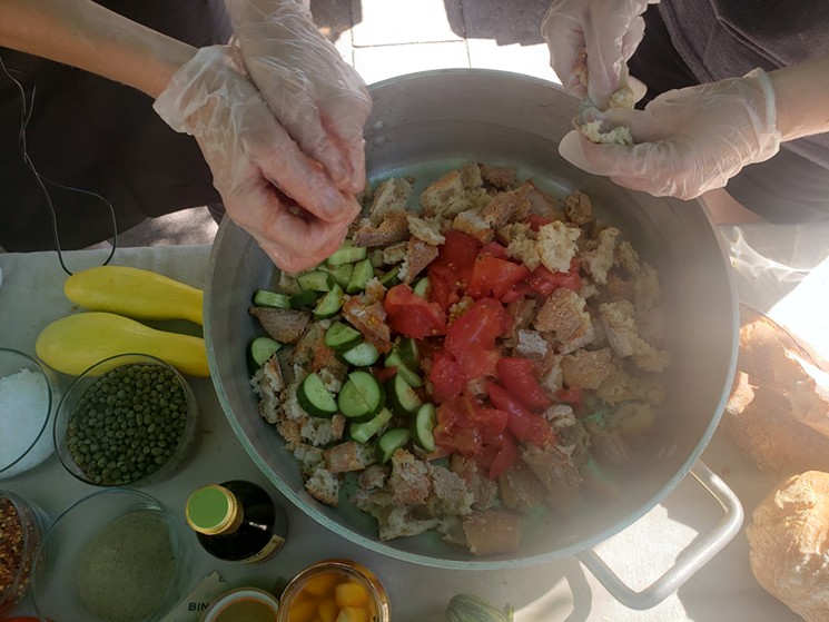 Making a panzanella-puttanesca salad during the chef's demo at the Union Station Farmers' Market. - LINNEA COVINGTON