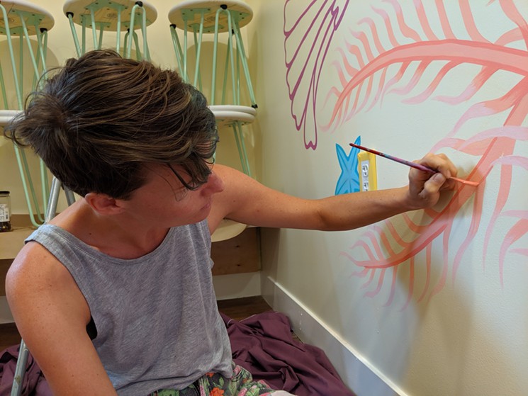 Artist Lindee Zimmer adds a mural to the wall inside Somebody People. - ANDREW FREDRICKSON