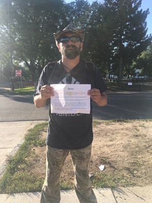 Wolf, who has been living in the encampment on 24th and California, holds a notice he received saying that the city will seize property unless it is moved within 48 hours. - SARA FLEMING