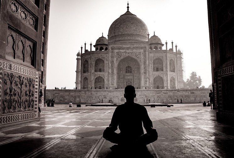 Weyi, in silhouette, meditating at the Taj Mahal. - COURTESY OF BRENTON WEYI