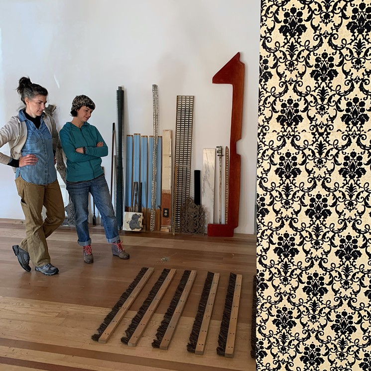 Risa and Meredith contemplate the hanging of broom brushes during the install of “Reconstructing Western Landscapes” at Alto Gallery. - HEATHER MOURER