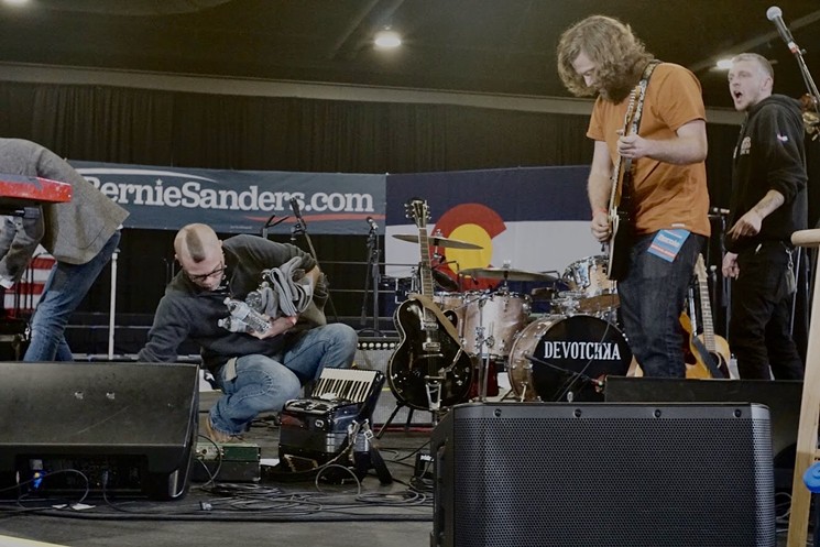 Dakota Diemand tunes a guitar at a Bernie Sanders rally last month. - PAUL SCHROEDER