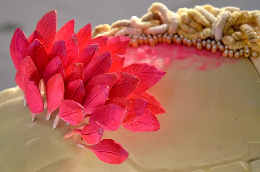 Pink wooden feathers: Jennifer Pettus and Rebecca Vaughan, "Why Was She Removed (And Then Put Back?),” detail, bobcat taxidermy blanks, yarn, gouache, faux pearl pins, perler beads, pen, metal windmill base, mdf, cardboard. - JENNIFER PETTUS AND REBECCA VAUGHAN